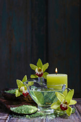 Spa set: liquid soap, sea salt on wooden spoon, scented candles.