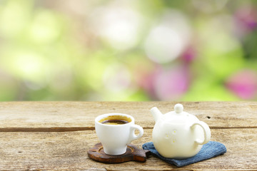 Tea cup with vintage old teapot on wooden table