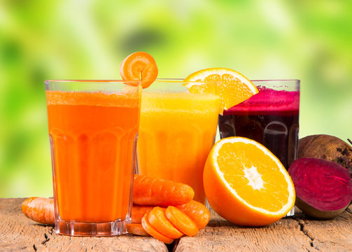 Fresh juice, mix fruits and vegetable, carrot, beetroot and orange drinks on wooden table. 