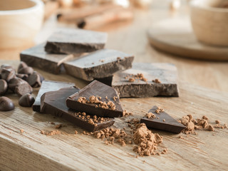Dark chocolate with cocoa on wooden table