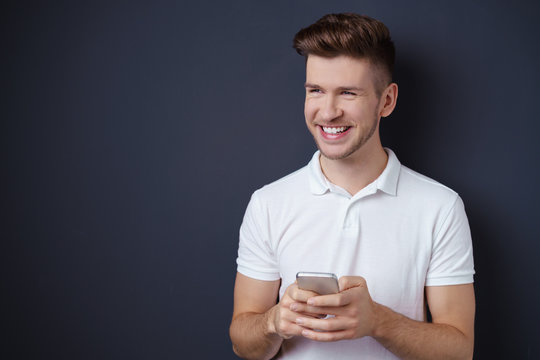 lachender junger mann mit seinem smartphone