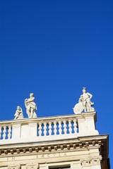 The statues and the mythology in the blue sky.