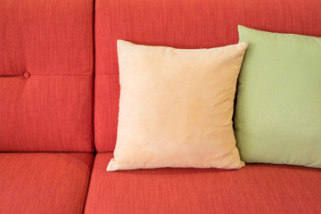 yellow and green pillows on orange sofa