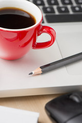 Coffee cup and laptop at office