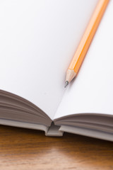 Empty notebook and yellow pencil