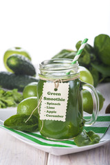 Bebida green smoothie o batido verde energético con frutas hojas de espinacas y verduras para una dieta sana en mason jar con pajita en espiral