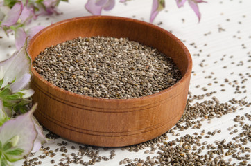 Chia seed healthy super food with flower over white wood backgro