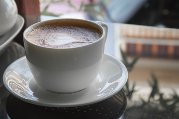 Close up cup of Coffee, latte on the black glass table