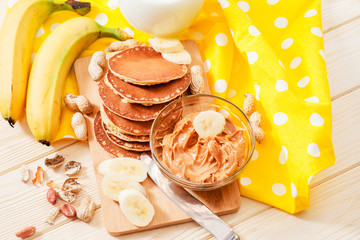 
hearty and healthy breakfast , American pancakes with bananas , nuts , peanut butter and milk on...