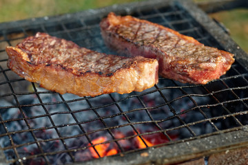 Two pieces of striploin steak on grill