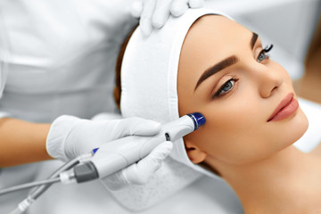 Fototapeta Face Skin Care. Close-up Of Woman Getting Facial Hydro Microdermabrasion Peeling Treatment At Cosmetic Beauty Spa Clinic. Hydra Vacuum Cleaner. Exfoliation, Rejuvenation And Hydratation. Cosmetology.  obraz