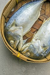 Fresh mackerel fishs in the basket on tile texture
