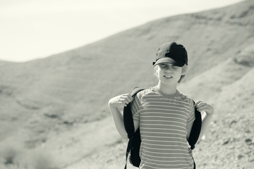 Cute 8 years old boy hiking in the desert