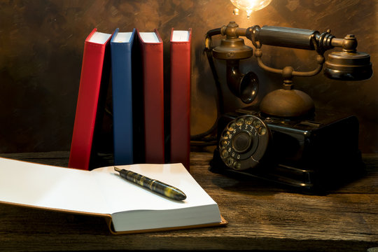 Still life of vintage telephone on table with diary book