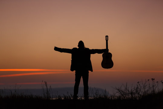 Man with guitar in sunset