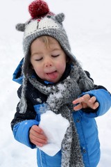 Small boy eats snow