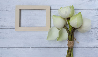 Fresh lotus flower bouquet with wood frame on white table