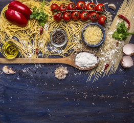 Ingredients for cooking pasta with vegetables, spices and herbs border ,place for text  on wooden rustic background top view close up