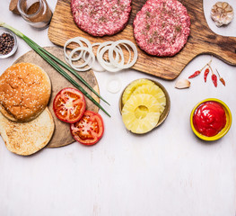cooking burger concept buns, cutlet of minced meat, onions, tomatoes, sauce border ,place for text  on wooden rustic background top view