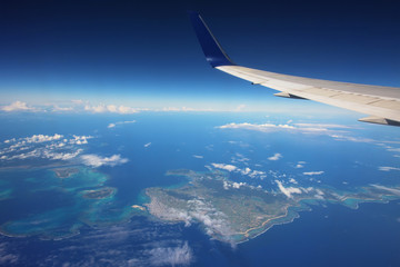 Wing of airplane above many islands