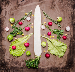 a variety of vegetables, laid out in the form of Christmas and New Year tree, radish, daikon, lettuce, Brussels sprouts on wooden rustic background top view close up