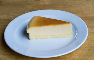 Cheesecake with dish on wooden background
