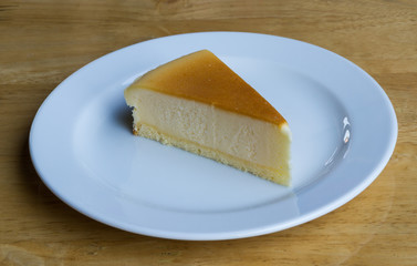 Cheesecake with dish on wooden background