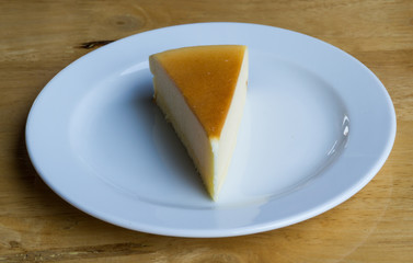 Cheesecake with dish on wooden background