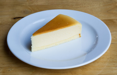Cheesecake with dish on wooden background