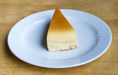 Cheesecake with dish on wooden background