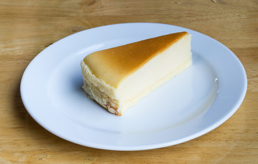 Cheesecake with dish on wooden background