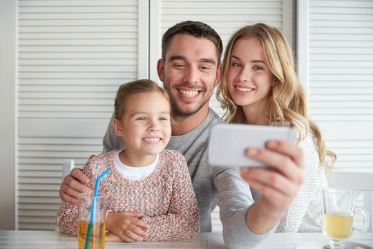 happy family taking selfie at restaurant