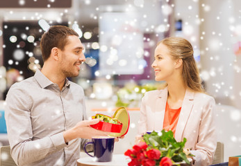 happy couple with chocolate box and roses in mall