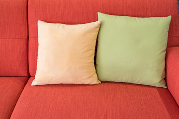 green and yellow pillows on red sofa