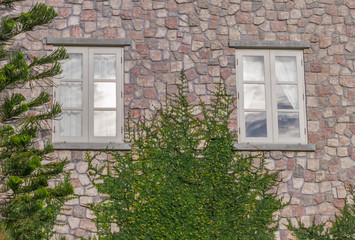 Fototapeta na wymiar Stone wall with small windows