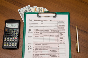 1040 Tax Return Form with calculator on wodden background