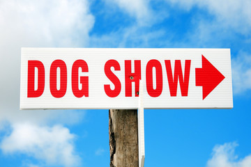 Dog show red and white arrow sign directing visitors to an outdoor event