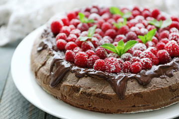 Cake with Chocolate Glaze and raspberries on wooden background
