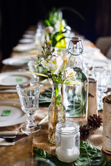 Decorated table ready for dinner. Beautifully decorated table set with flowers, candles, plates and serviettes for wedding or another event in the restaurant.