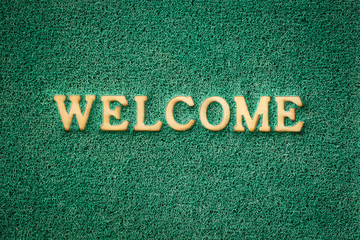 Green doormat for feet on a floor