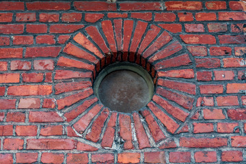Wall of an old brick building and round window