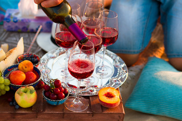Obraz na płótnie Canvas Glasses of the red wine on the sunset beach