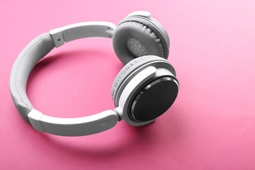 Fototapeta na wymiar Wireless white and grey headphones on pink background