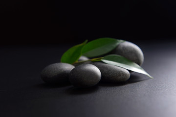 Pebbles with leaf on black background