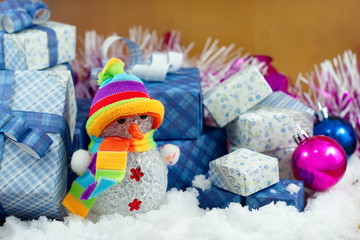 Fototapeta na wymiar Snowman and gift box on the snow field.