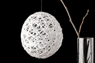 Alder branch in the glass with a white christmas ball on the bla