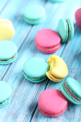 Tasty colorful macarons on a blue wooden table