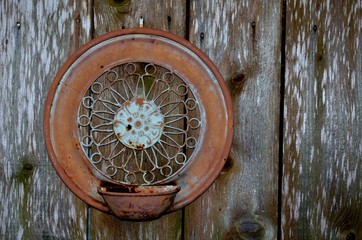 Rustic backyard wall decoration, hanging on a worn weathered fence