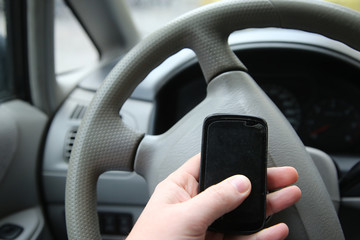 man sitting in the car and holding a touch phone