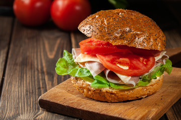 Delicious sandwich with prosciutto ham, cheese and vegetables
